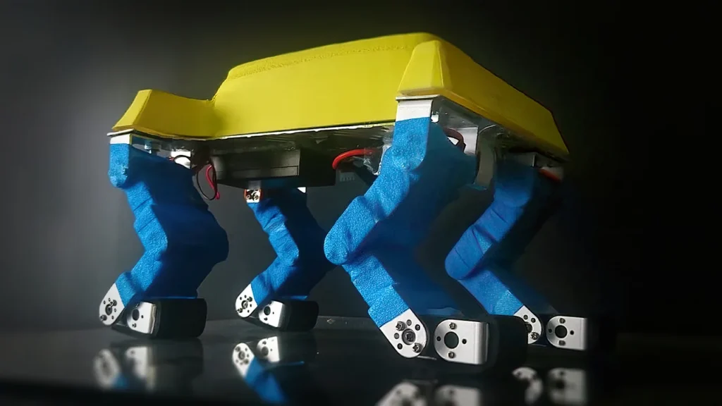 Custom quadruped robot with blue articulated legs and yellow body designed and built by Mr.Q.
